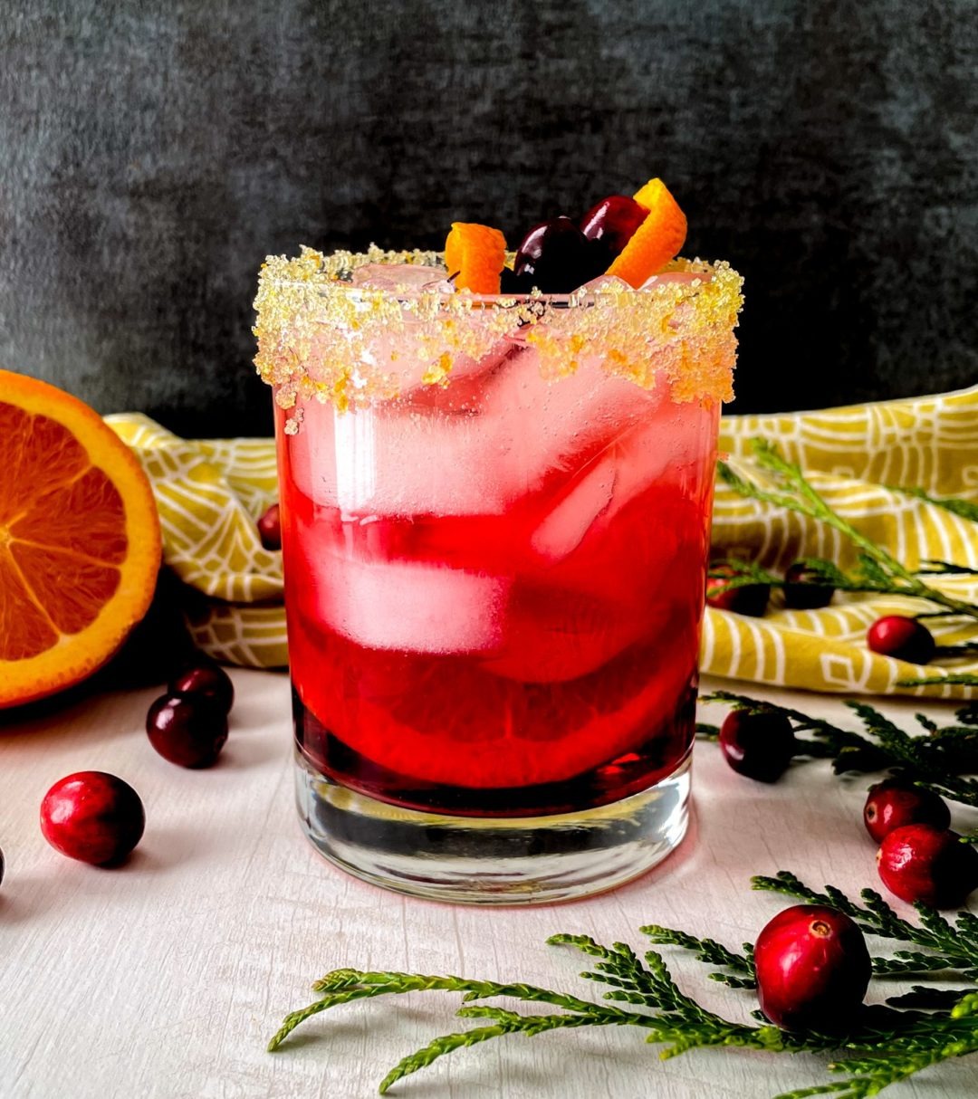 A bright pink mocktail featuring cranberries, fresh orange, and ginger beer.