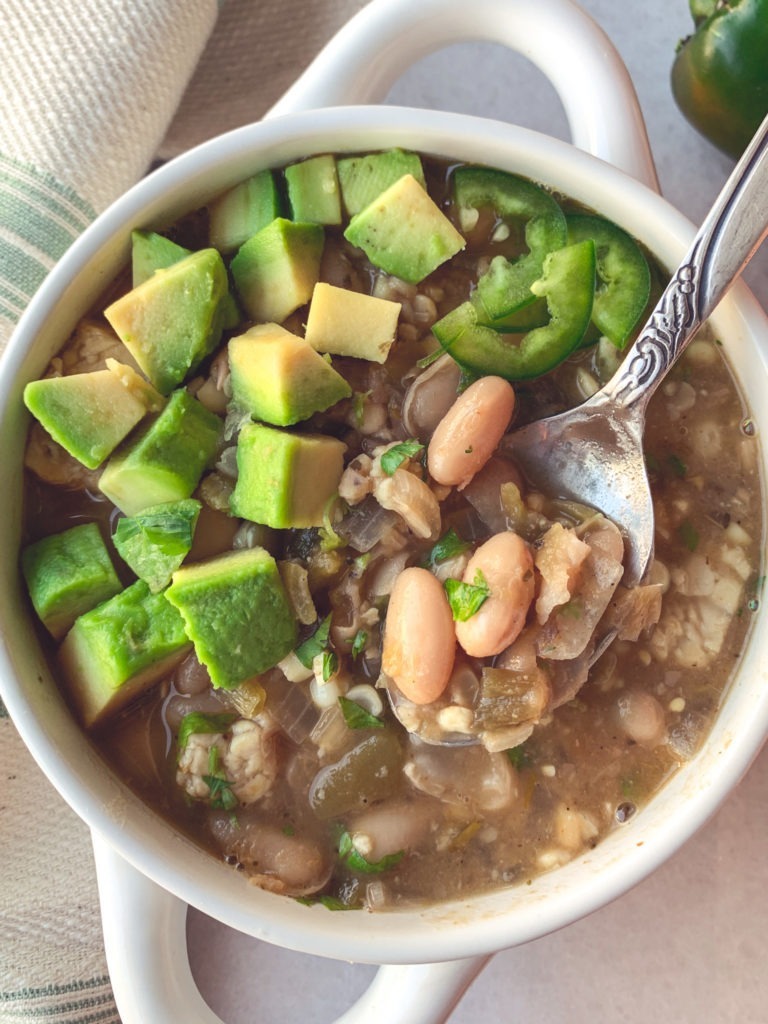 Vegan and gluten-free chili made with tempeh and white beans, and topped with avocado, cilantro, and jalapenos. 