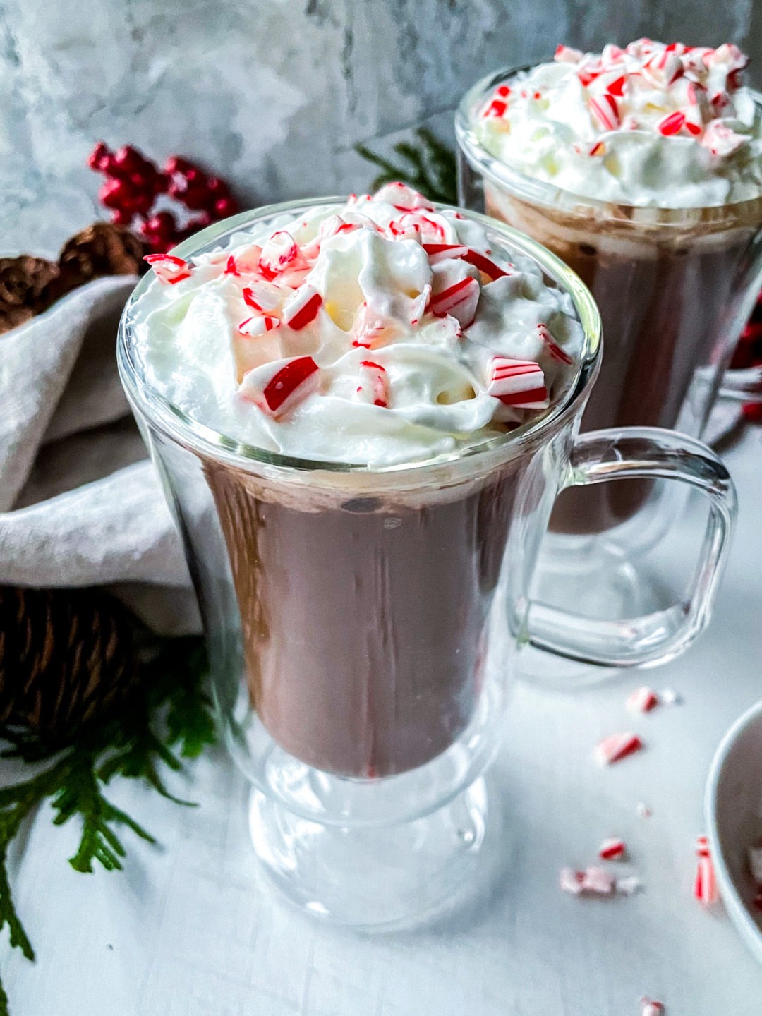 Creamy vegan hot chocolate with coconut whipped cream and crushed candy canes.